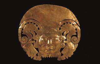 Corona de oro que representa un rostro humano flanqueado por felinos rampantes